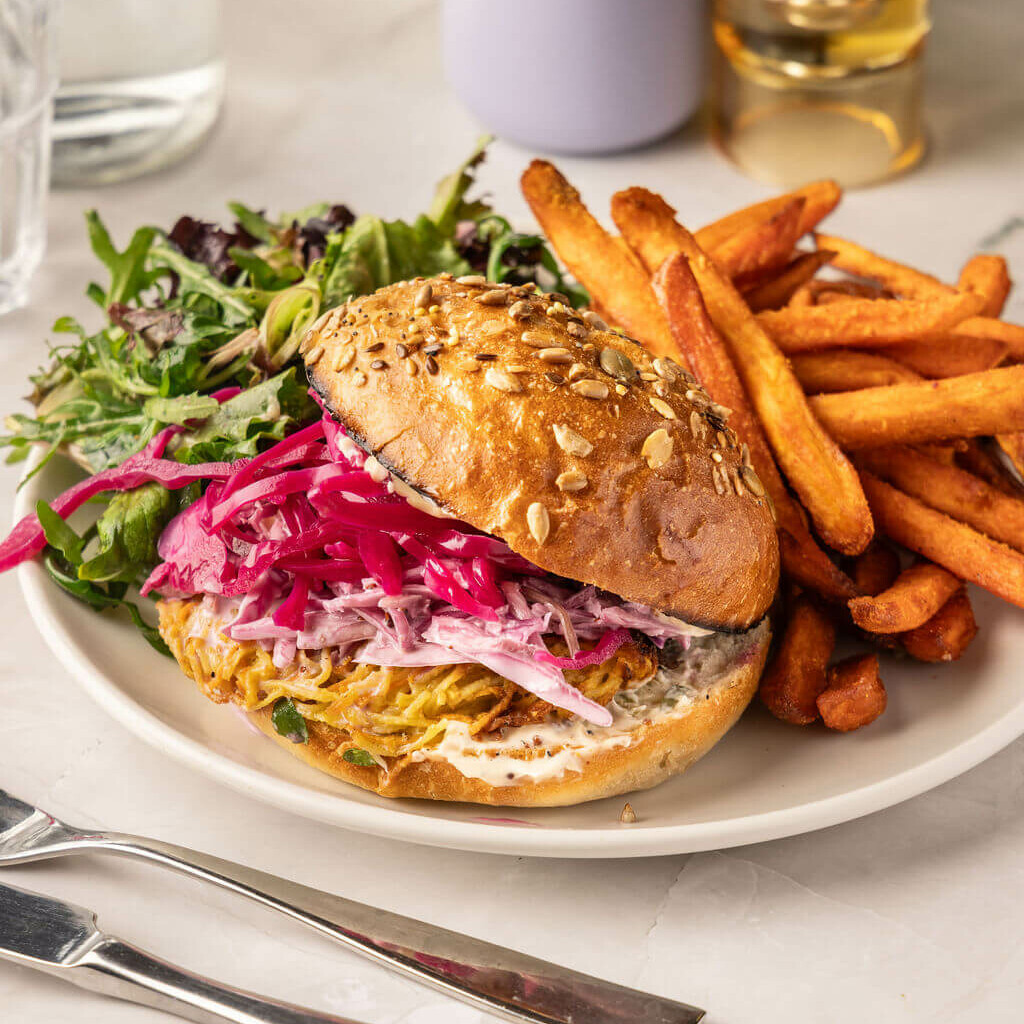 Burger veggie au rösti de légumes, pickles et frites de patates douces – alternative végétarienne pleine de goût.