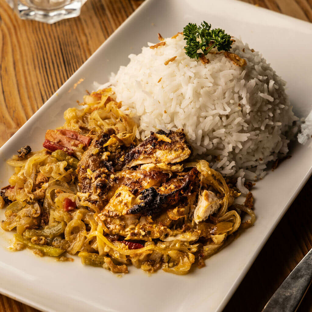 Yassa au poulet grillé accompagné de riz et d'oignons confits – plat traditionnel du Sénégal