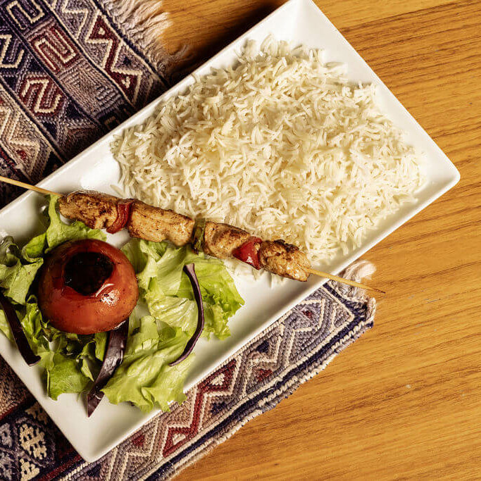 Brochette de poulet grillé avec légumes, accompagnée de riz basmati et salade, plat afghan du restaurant Ashiana.