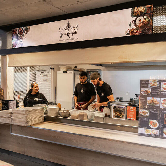 Stand Java Rempah à La Commune avec l’équipe en cuisine préparant des plats indonésiens, comptoir en bois et carte visible